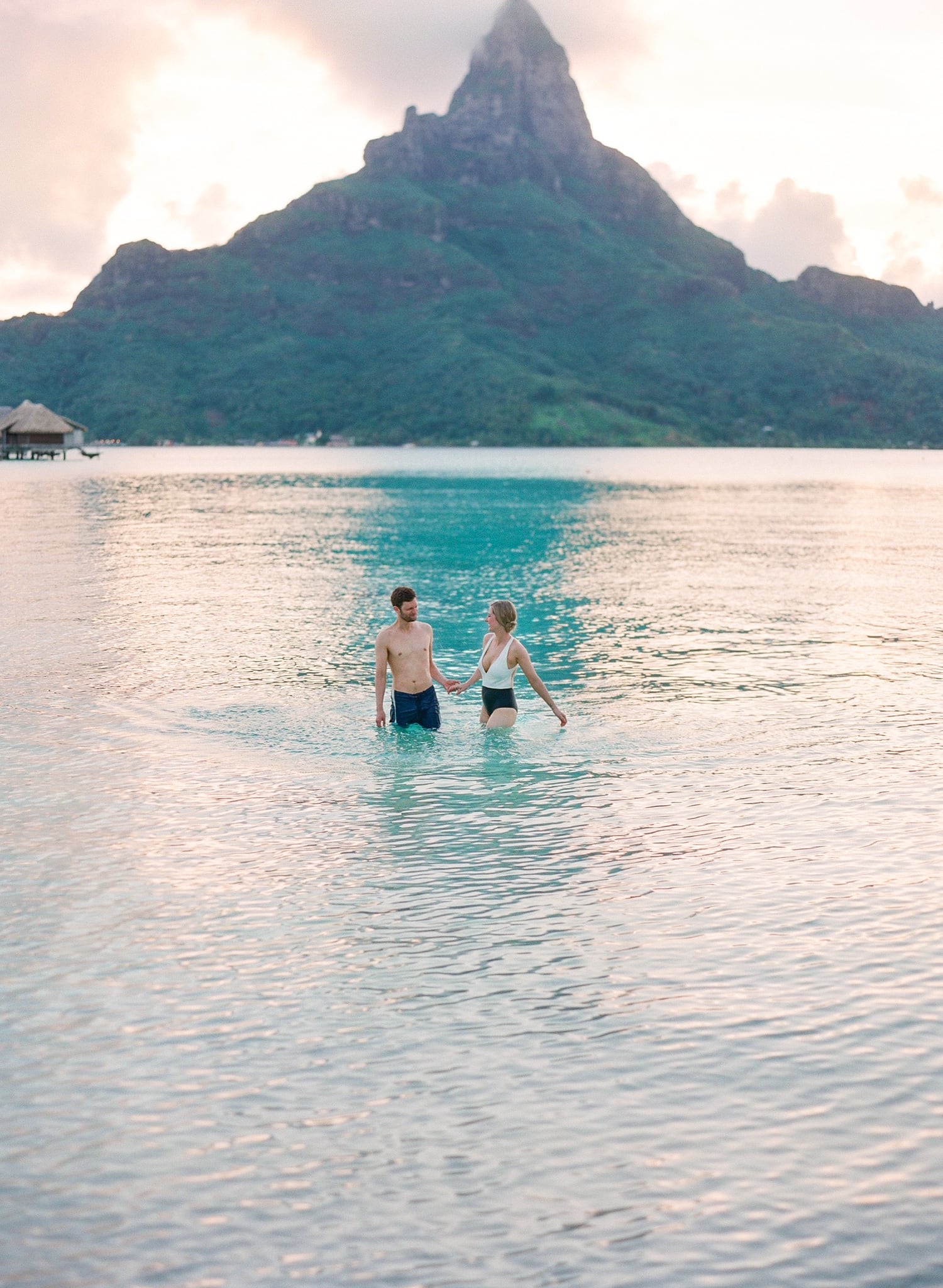 Couple in the water on honeymoon in front of the mount Otemanu